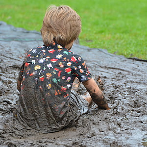 person wearing multicolored shirt while sitting on brown mud thumbnail