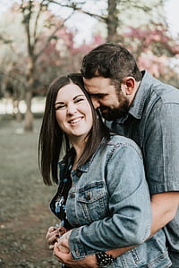 shallow focus photography of man hugging a woman from behind thumbnail