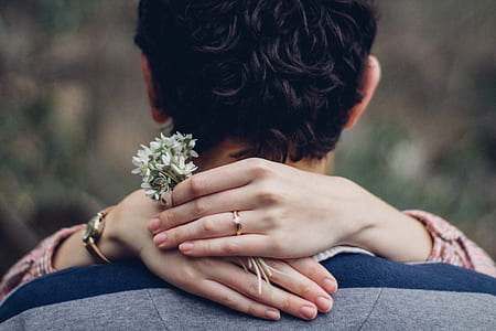 woman holding white flowers hugging a man thumbnail
