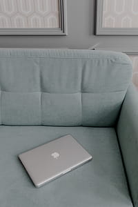 MacBook laptop lying on mint couch thumbnail