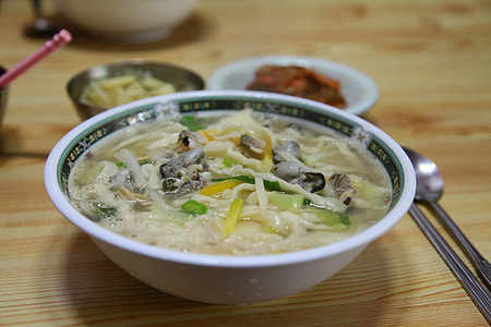 selective focus photography of round bowl with soup beside gray spoon on brown wooden surface thumbnail