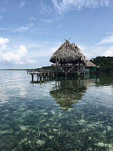 gray nipa hut on body of water thumbnail