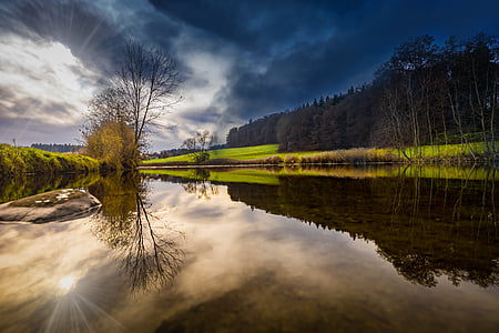 landscape photography of body of water under nimbus clouds thumbnail