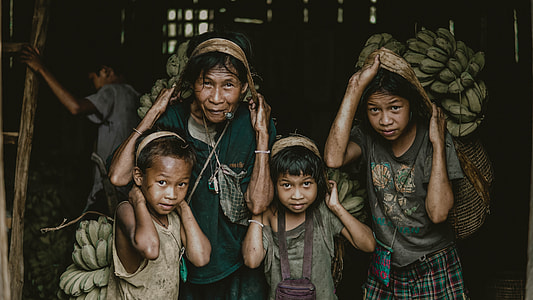 photo of mother and children holding green bananas thumbnail