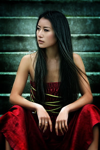 woman wearing red strapless dress sitting on gray concrete stair thumbnail