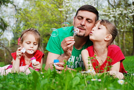 man beside children on grass field thumbnail