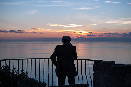 silhouette of man standing near handrail thumbnail