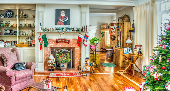 pink sofa chair near white mantel fireplace and christmas tree thumbnail