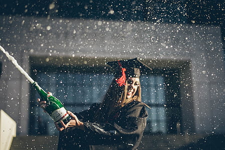 woman wearing academic gown holding green bottle thumbnail