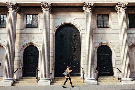 woman walking near concrete building thumbnail