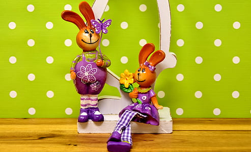 two rabbit figurines wearing purple dresses thumbnail
