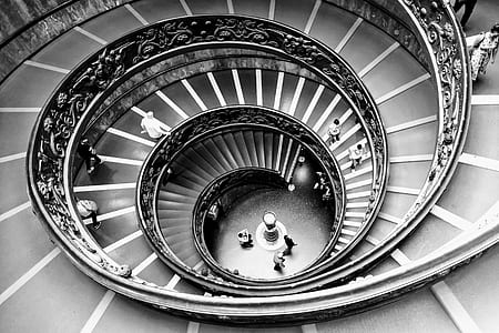 grayscale photo of people walking on spiral staircase thumbnail