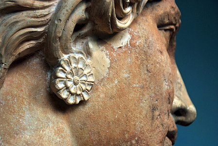 closeup photography of person wearing earrings statue thumbnail