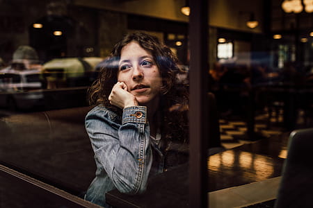 Woman Wearing Blue Denim Jacket Putting Her Right Arm on Her Cheek thumbnail