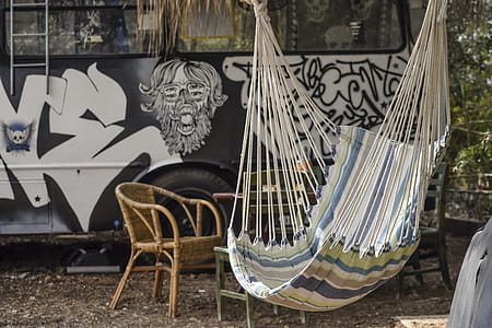 Multicolored Hammock Near Brown Rattan Armchair thumbnail