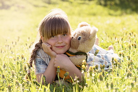 girl wearing white and blue floral dress laying on grass thumbnail