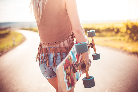 Young Woman Walking on The Road and Holding Longboard thumbnail