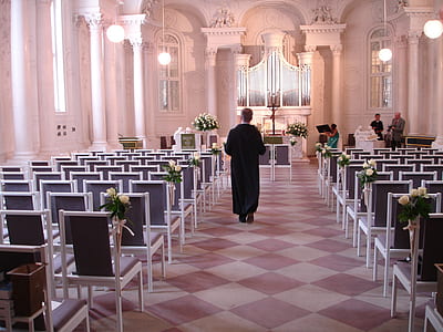 person walking in front of altar thumbnail