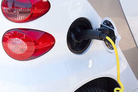 black gasoline nozzle in vehicle gas tank hole thumbnail