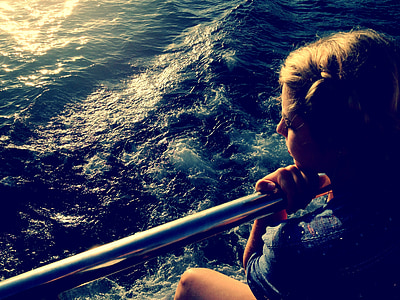 woman holding stainless steel railings above body of water thumbnail