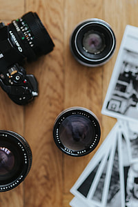 Old Zenit camera and a Canon camera with black-and-white photos on a wooden table thumbnail