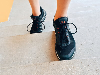 person wearing pair of black Under Armour sneakers thumbnail