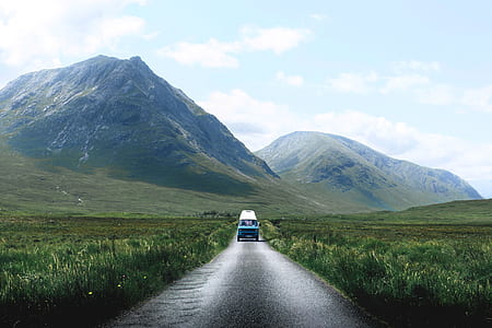landscape photography of vehicle on freeway near mountain range thumbnail
