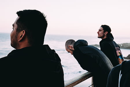three men standing in front railing thumbnail