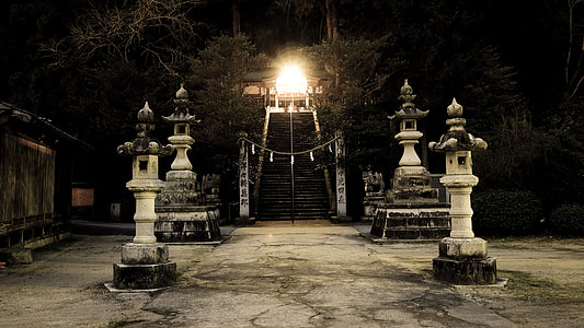 four white pillars with light fixture above during night time thumbnail