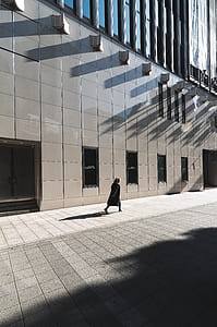person walking near high-rise building during daytime thumbnail