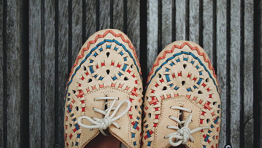 person wearing pair of beige-blue-and-red sneakers thumbnail