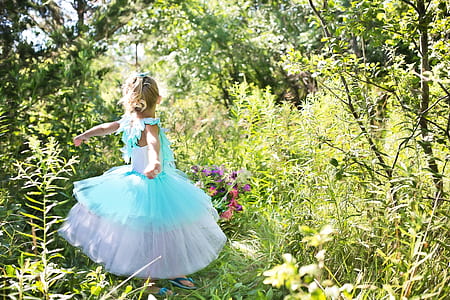 girl wearing blue and white tutu dress standing on grass thumbnail