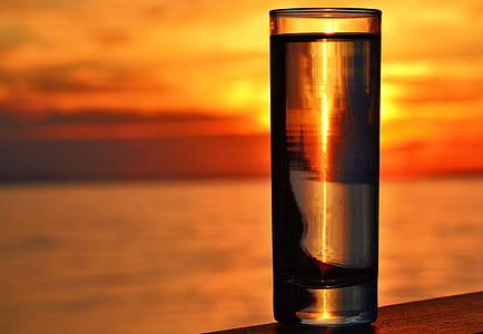 Clear Highball Glass on Brown Surface during Golden Hour thumbnail