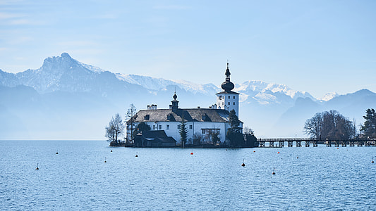 white and brown castle surrounded by water under blue sky during daytime thumbnail