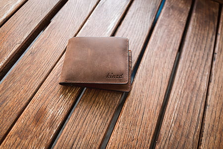 brown leather bifold wallet on brown wood planks thumbnail