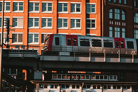 White and Red Train Near Brown Concrete Building thumbnail