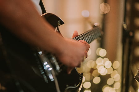 bokeh photography of person playing guitar thumbnail