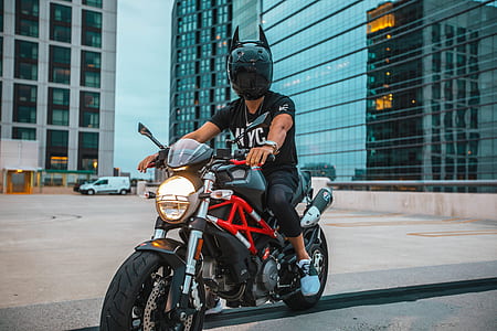 man riding on black and red naked motorcycle outdoor thumbnail