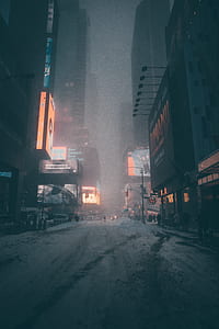 gray concrete road in between buildings at night time thumbnail