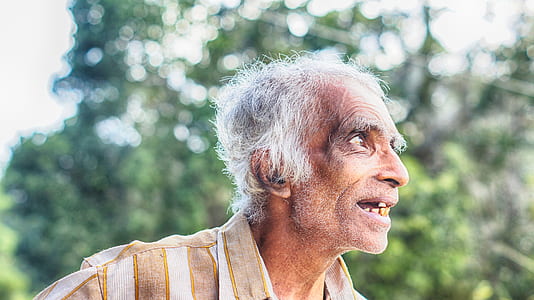 smiling man in brown and white striped collared shirt thumbnail