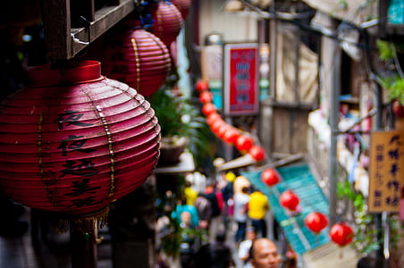 round red lanterns hanging from ceiling of building during daytime thumbnail