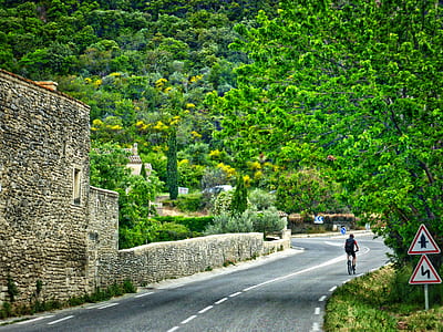person biking passing on road during daytime thumbnail