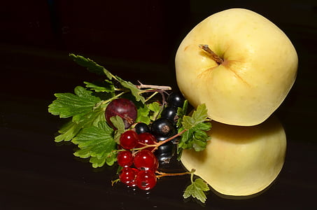 two yellow apples beside cherries thumbnail