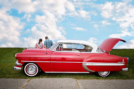 man and woman near red car thumbnail
