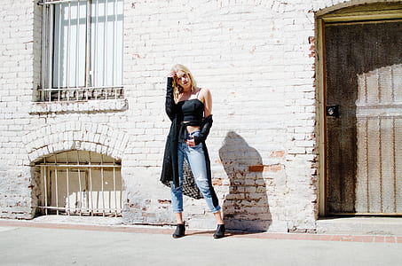 woman standing posing near white brick wall thumbnail