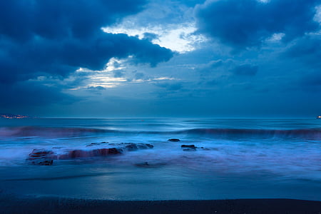 body of water near seashore under cloudy sky thumbnail