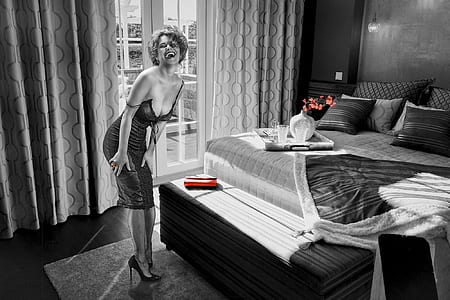 grayscale photo of woman standing near mattress thumbnail