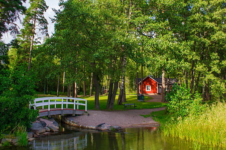 red and white wooden house surrounded by trees thumbnail