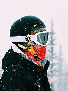 person wearing snow jacket, helmet, and goggles with face mask on snow thumbnail