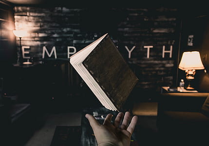 person pointing at brown book thumbnail